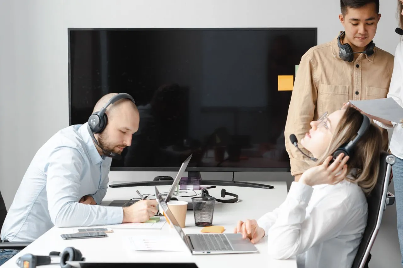 Contact centre team at work with headsets and laptops