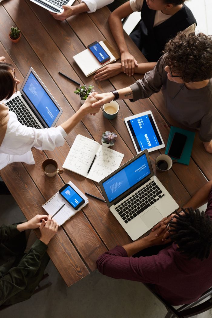 The Art of Drawing Readers In: Your attractive post title goes here A diverse group of professionals brainstorming in a modern workspace with laptops and notebooks.